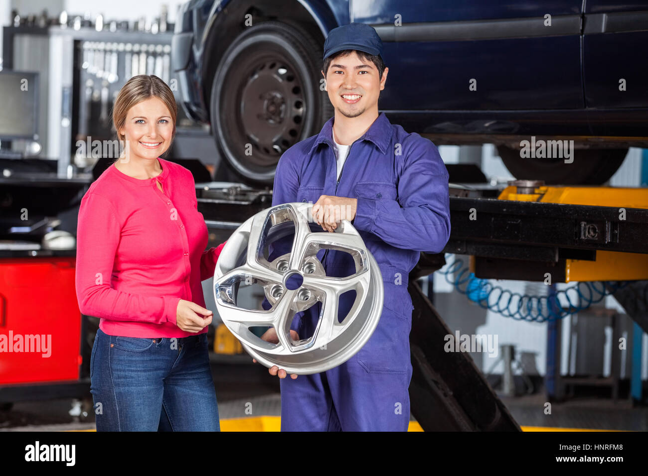 Happy Mechanic And Customer With Hubcap Stock Photo