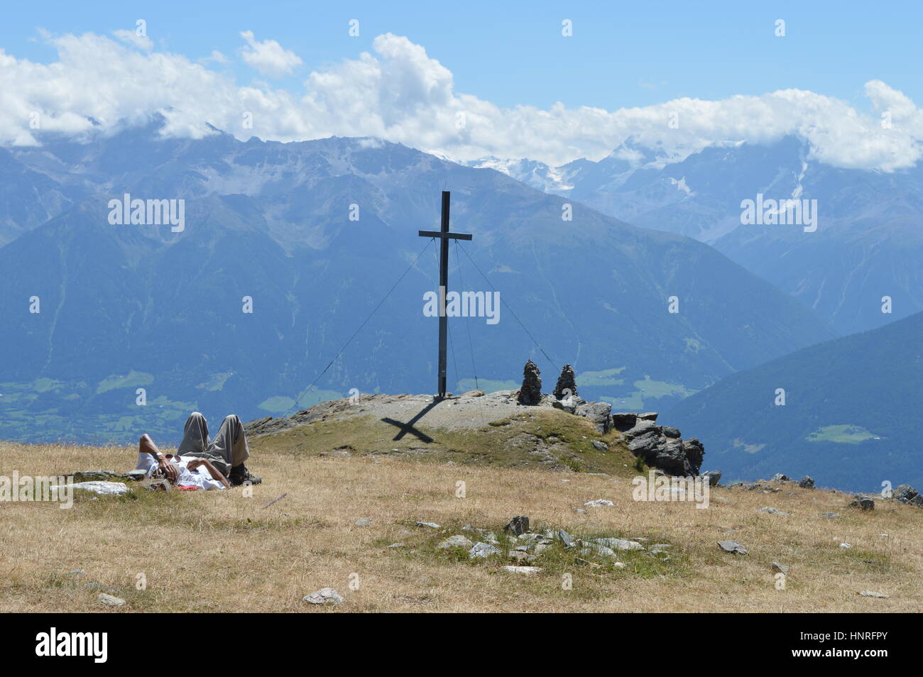 Vinschgau, Italy - July 31, 2015: Lonesome climber takes break on top of mountain Spitzige Lun near Matsch in South Tryol towards Etschtal, Vinschgau  Stock Photo