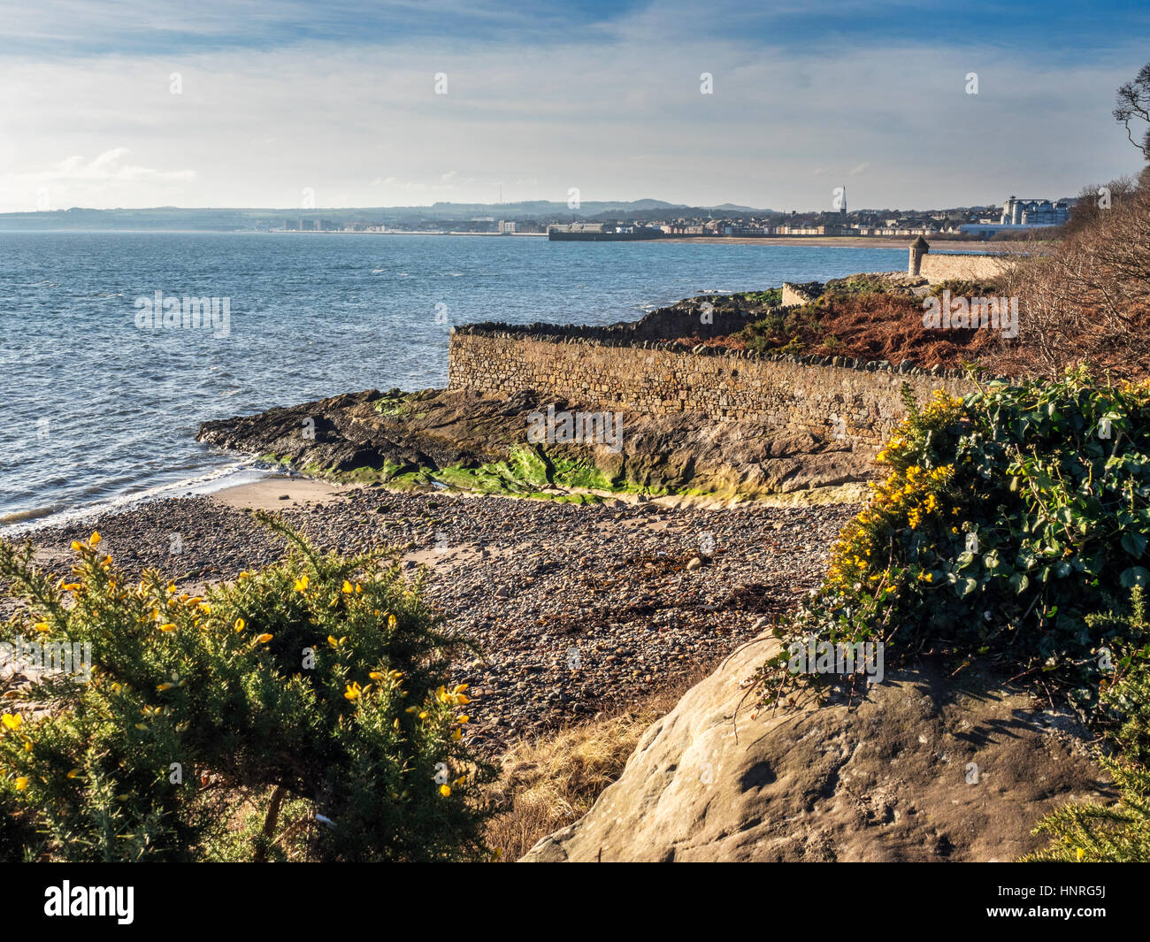Boundary wall below Ravenscraig Park with Lookout Tower and view to Kirkcaldy beyond from the