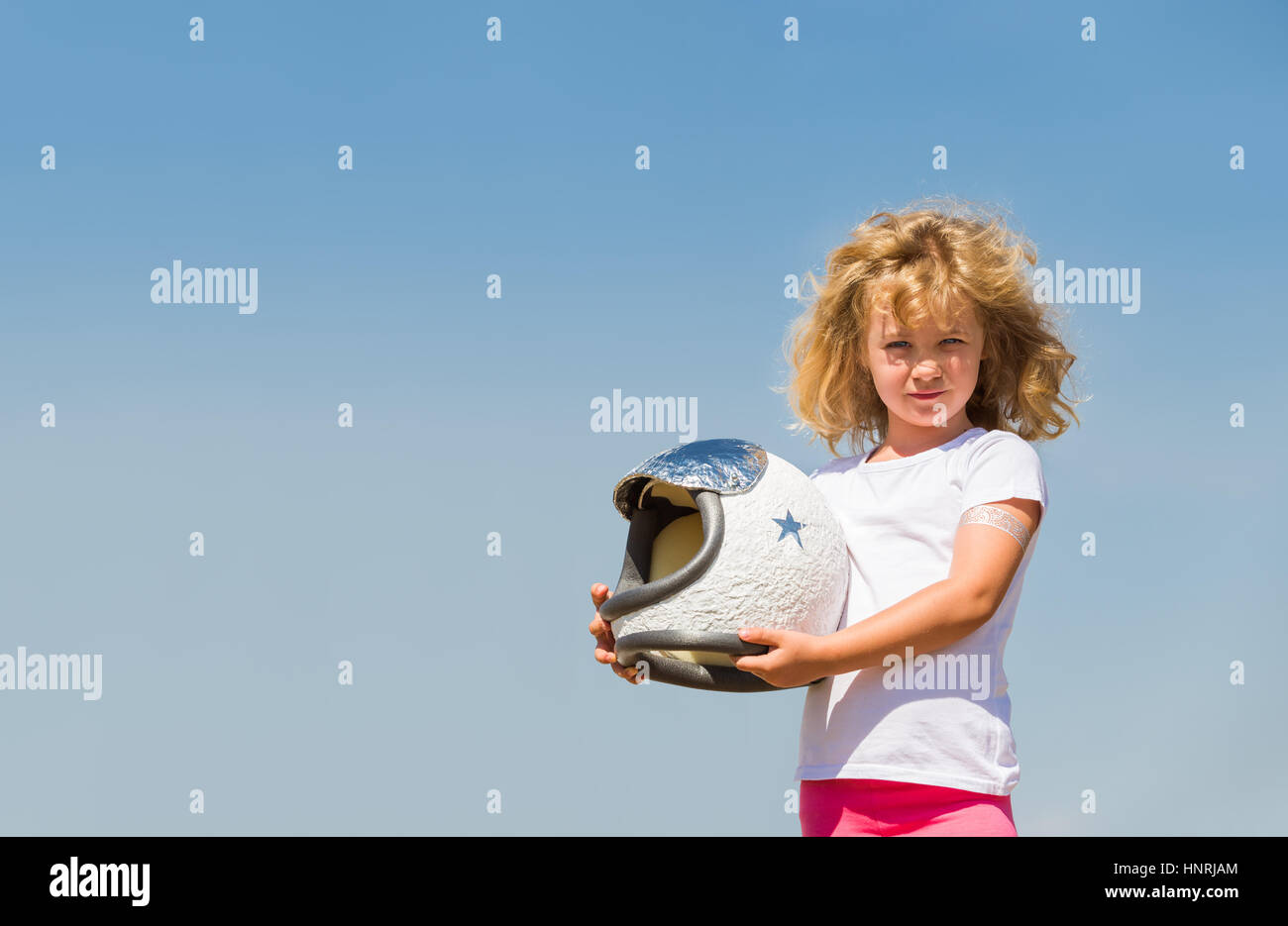 Portrait of blonde little girl in an astronaut costume dreaming of becoming a spacemen Stock Photo
