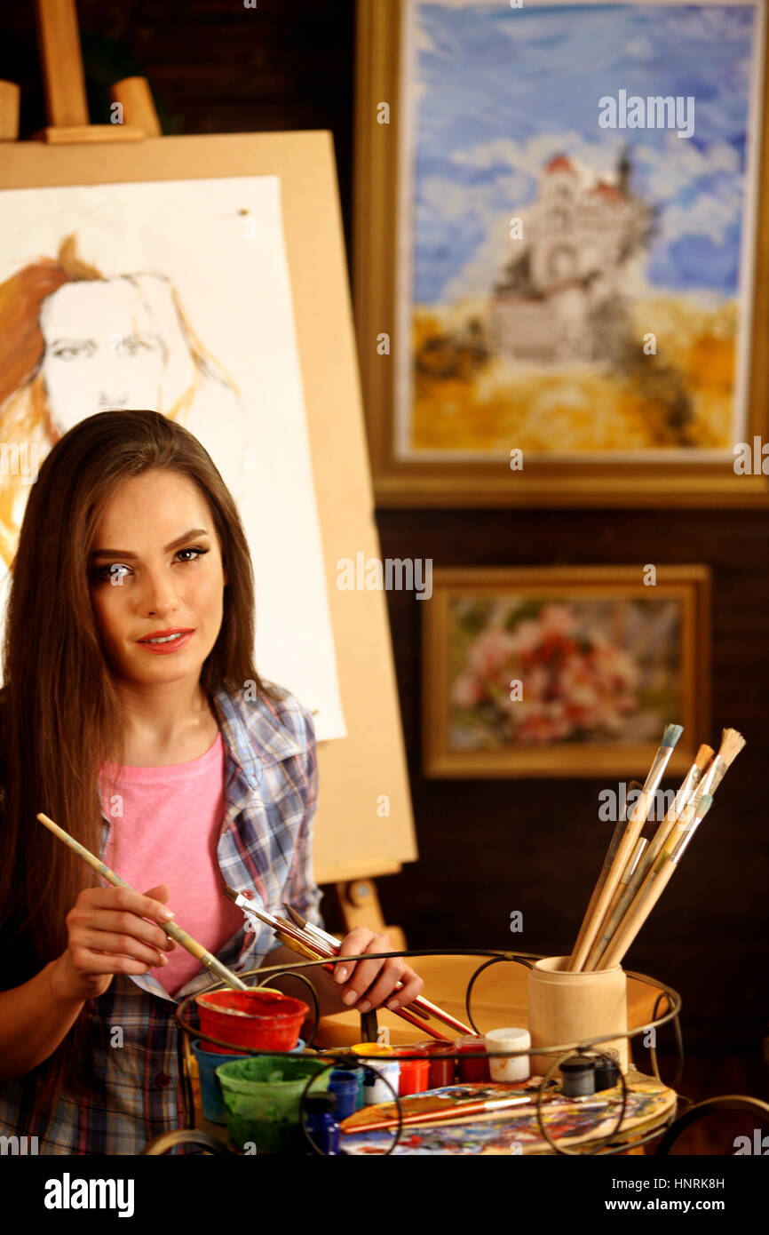 Artist painting on easel in studio. Girl paints portrait of woman with ...