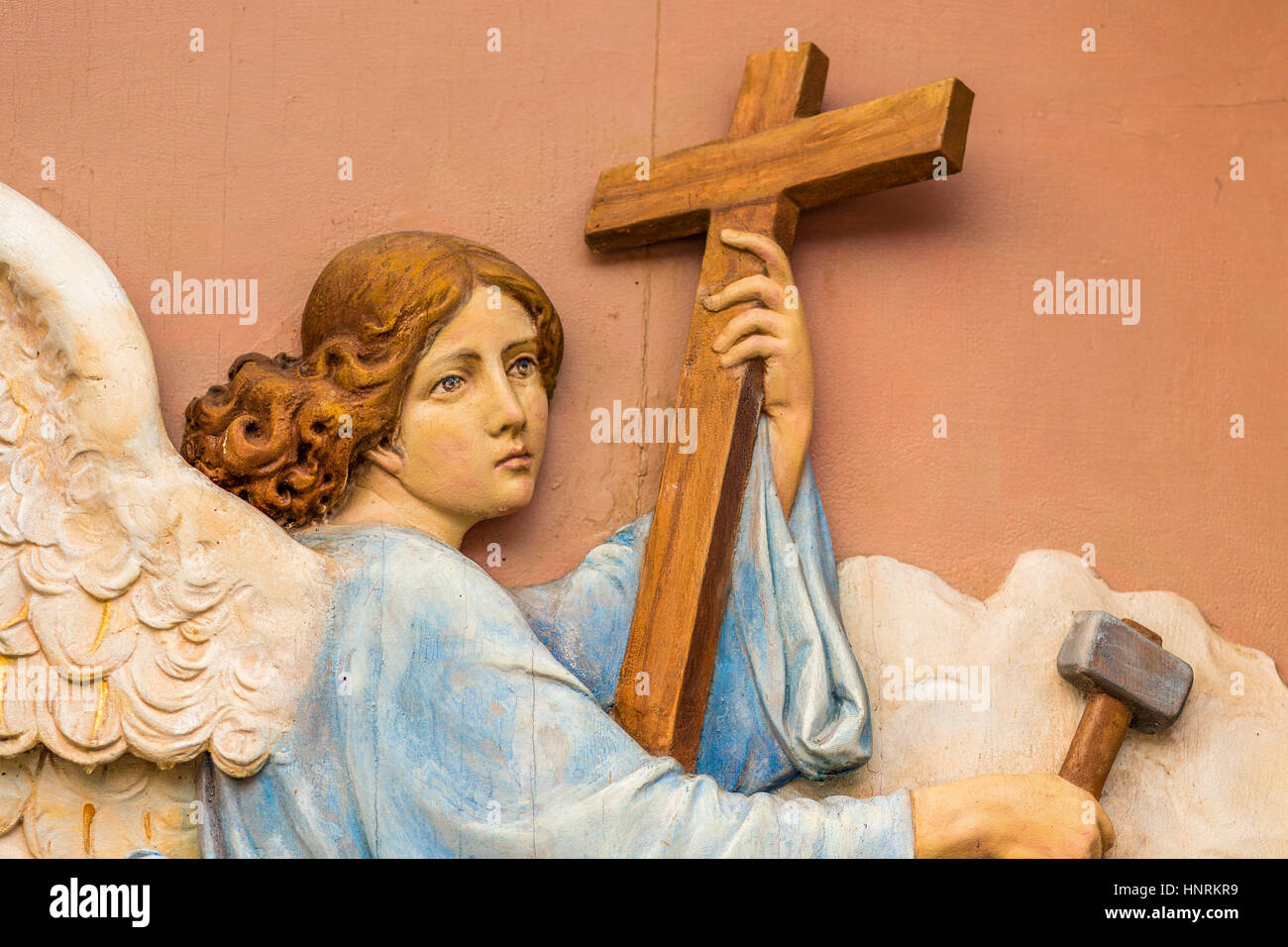 detail of vintage statue of angel holding Cross and hammer Stock Photo -  Alamy