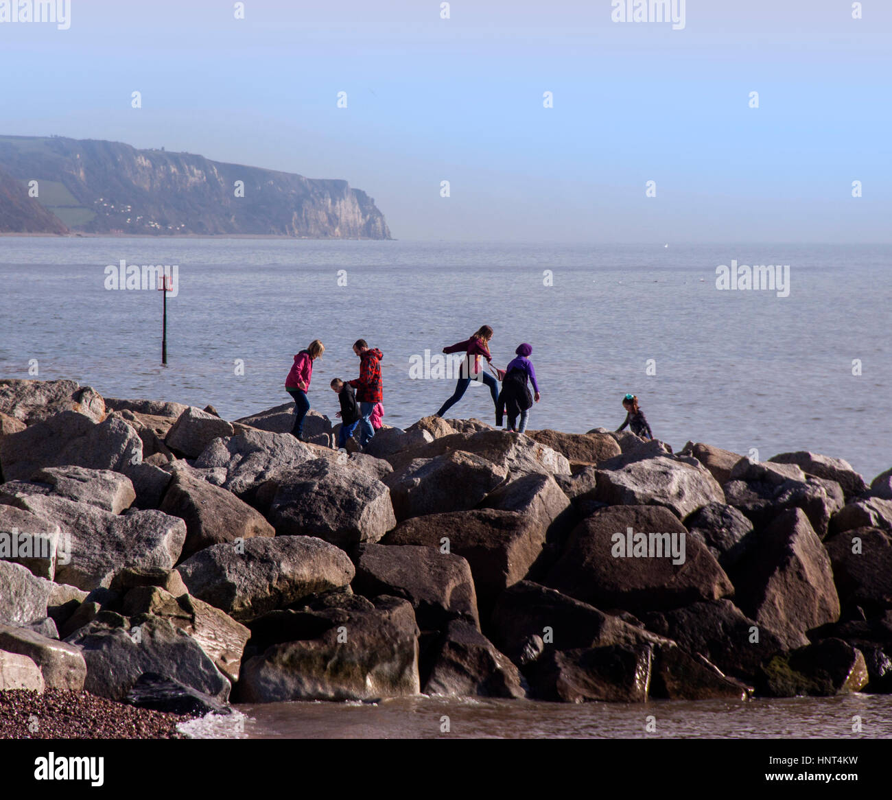 Sidmouth, Devon, UK. 16th Feb 2017. Half term playtime on the rock groynes at Sidmouth, Devon. Photo: South West Photos / Alamy Live News Stock Photo