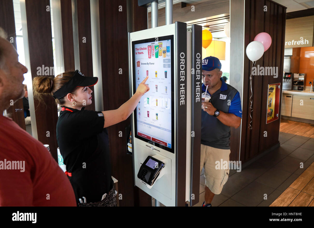 Florida, USA. 16th Feb, 2017. Carlos Lopez (right) places an order on a kiosk at McDonald's on Palm Beach Lakes Boulevard in West Palm Beach while McDonald's employee Anna Maria helps customer Steven Buckley (left) with his order Thursday, February 16, 2017. ''This is my first time using the kiosk, '' said Lopez. ''It is pretty neat. Simple, convenient, and fast. Credit: Bruce R. Bennett/The Palm Beach Post/ZUMA Wire/Alamy Live News Stock Photo