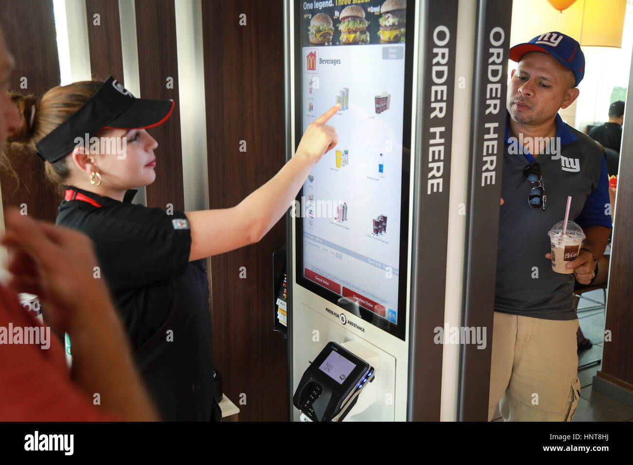 Florida, USA. 16th Feb, 2017. Carlos Lopez (right) places an order on a kiosk at McDonald's on Palm Beach Lakes Boulevard in West Palm Beach while McDonald's employee Anna Maria (left) helps customer Steven Buckley (far left) with his order Thursday, February 16, 2017. ''This is my first time using the kiosk, '' said Lopez. ''It is pretty neat. Simple, convenient, and fast. Credit: Bruce R. Bennett/The Palm Beach Post/ZUMA Wire/Alamy Live News Stock Photo