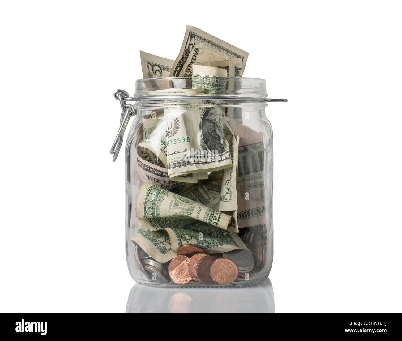 A tip jar or jar for savings filled over the top with American coins