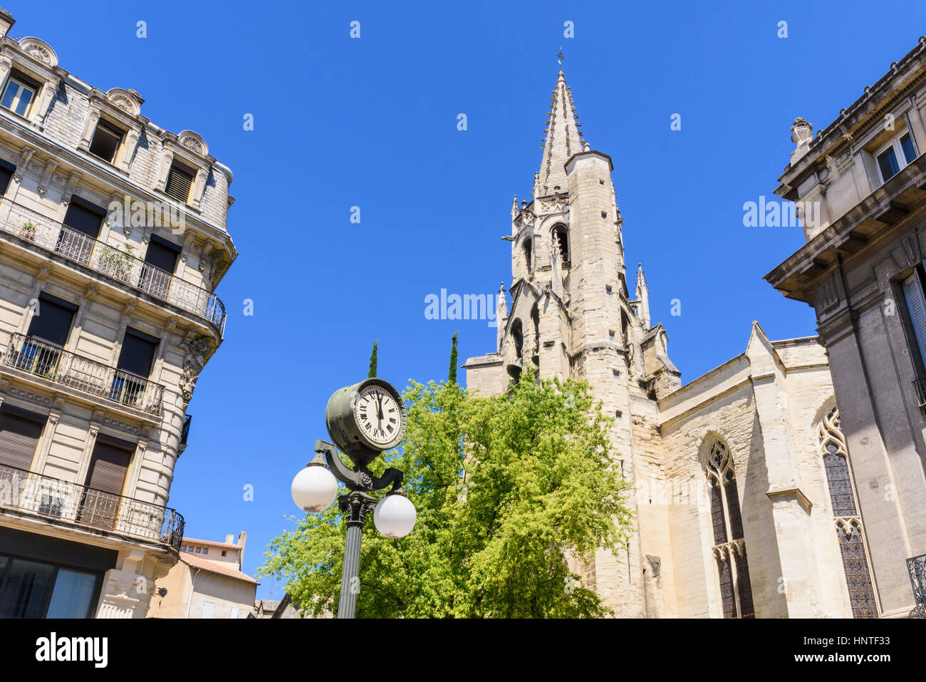 Basilique Saint-Pierre and old street light with clock in Place Carnot, Avignon, France Stock Photo
