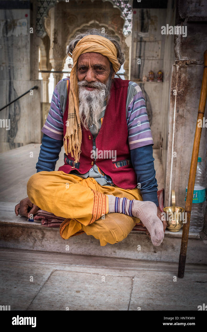 Old indian man sitting at the entrance to the lake at Pushkar India Stock Photo