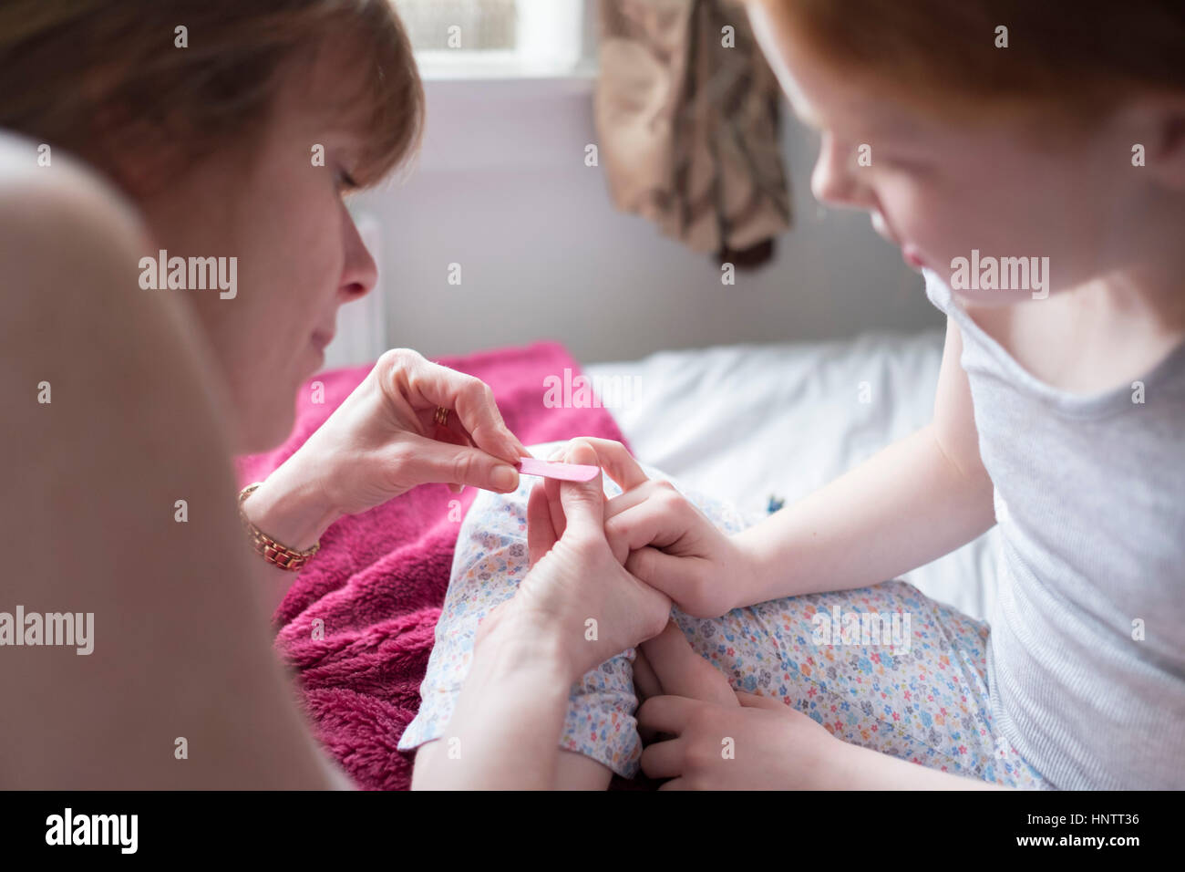 A little girl having her nails filed by her mother Stock Photo - Alamy