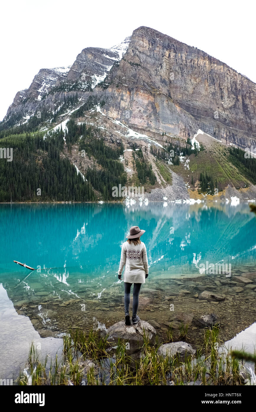 A Girl in a hat and bohemian sweater near the mountain lake Stock Photo
