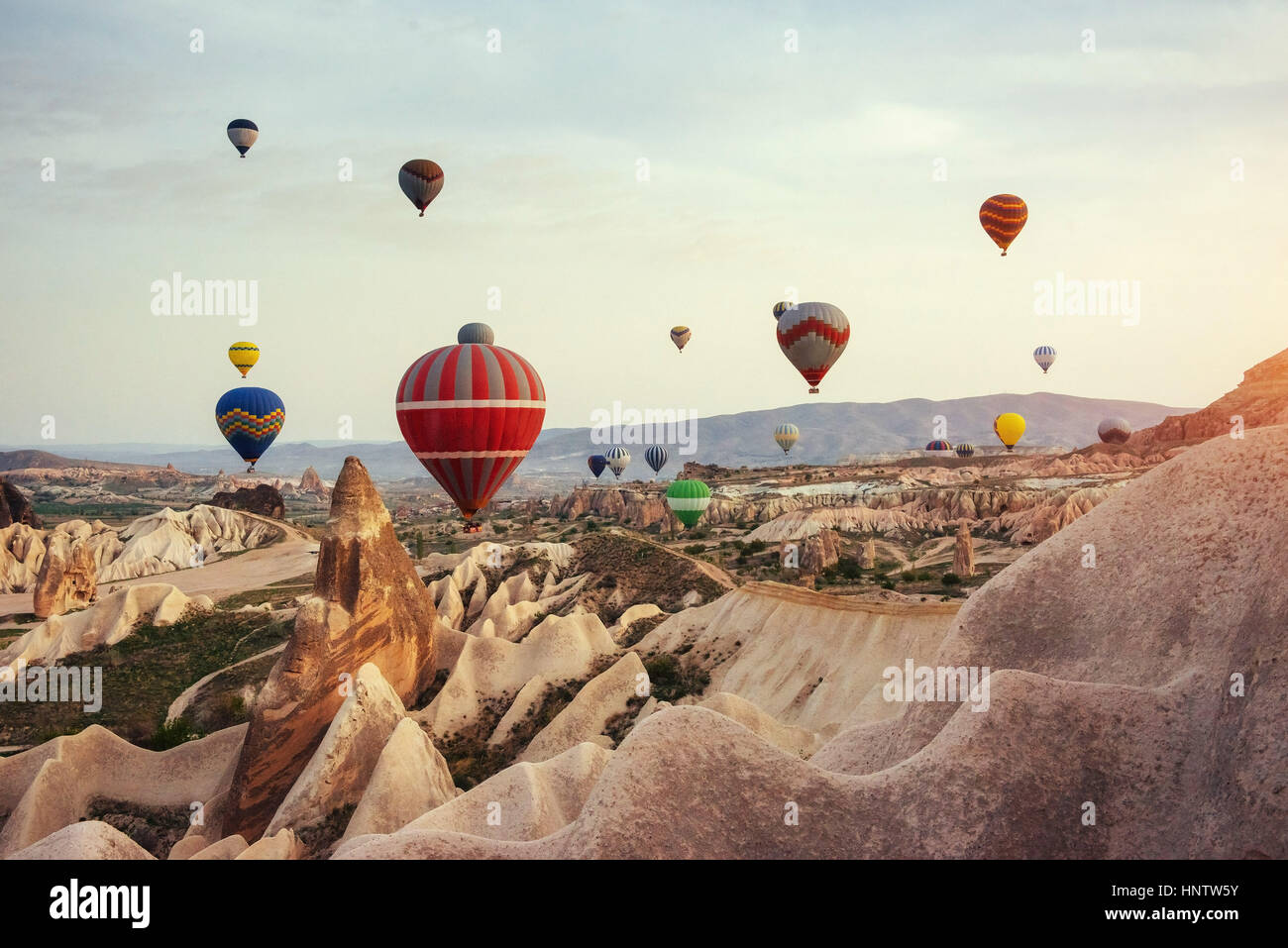 Hot air balloon flying over rock landscape at Cappadocia Turkey. Stock Photo