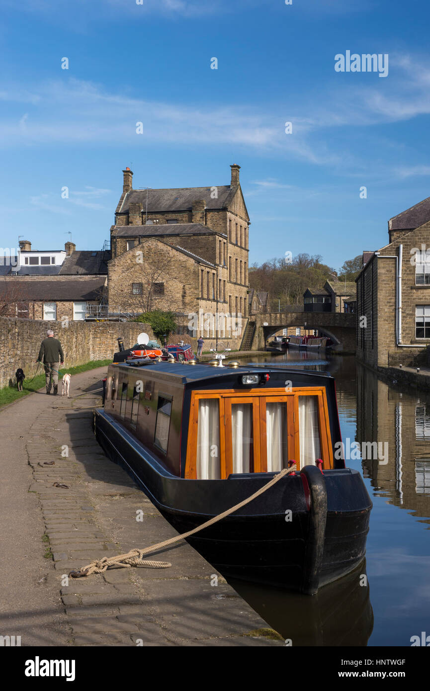 Dog walker on the towpath and canal boats moored at the visitor moorings - Leeds Liverpool Canal in the town of Skipton, North Yorkshire, England. Stock Photo