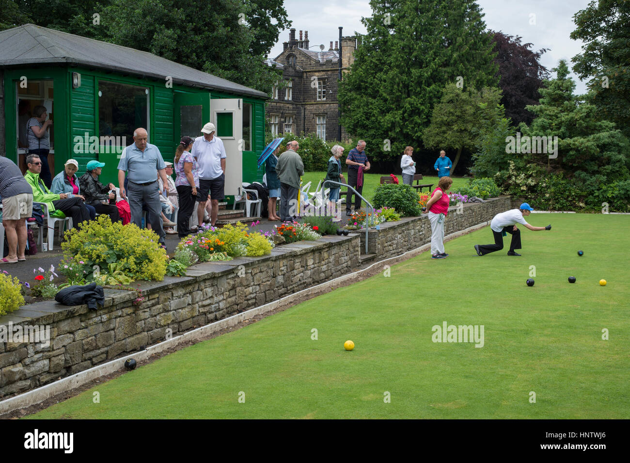 Competitors and spectators at a crown green bowling match on the bowling green in the village of Burley In Wharfedale, West Yorkshire, England. Stock Photo