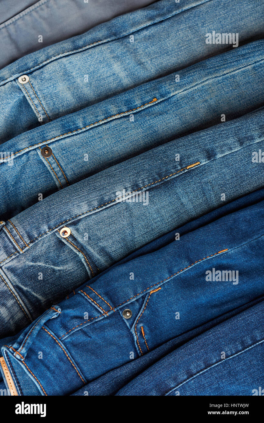 Colorful blue jeans background close up stack. Jeans lay on shop display Stock Photo
