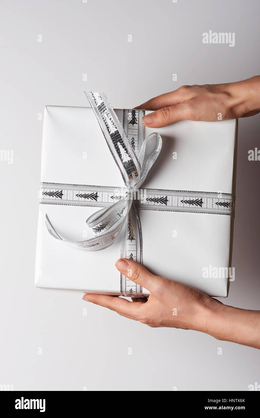 One big white gift present box in hands close up view from top Stock Photo