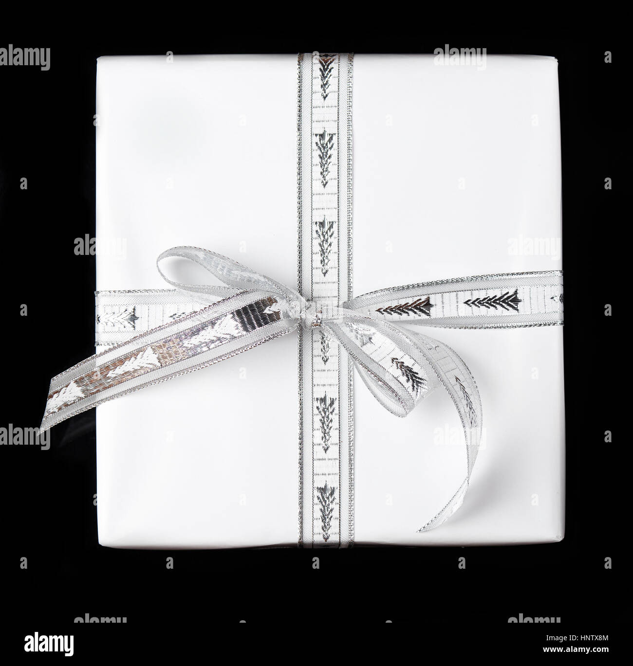 One white gift with ribbon box on black background isolated Stock Photo