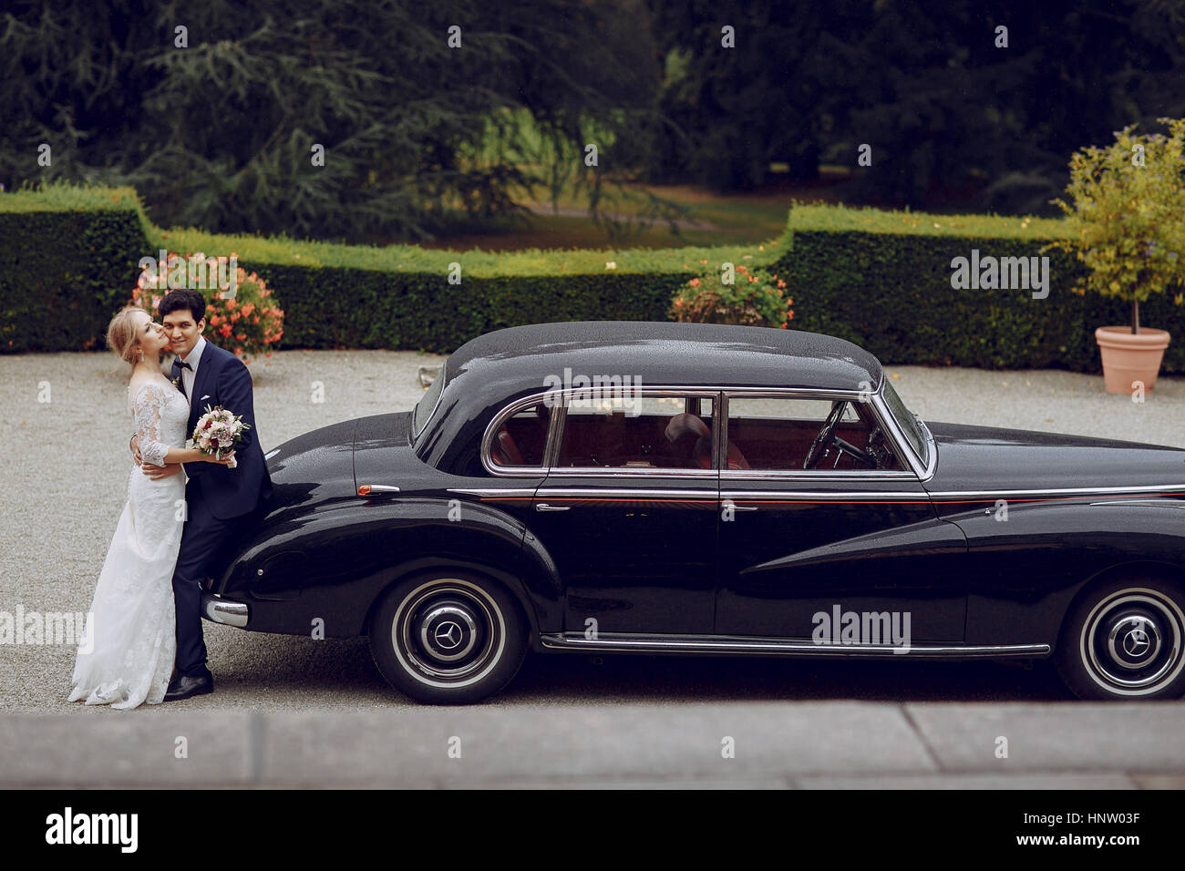 bride and groom standing in the yard near the car Stock Photo - Alamy