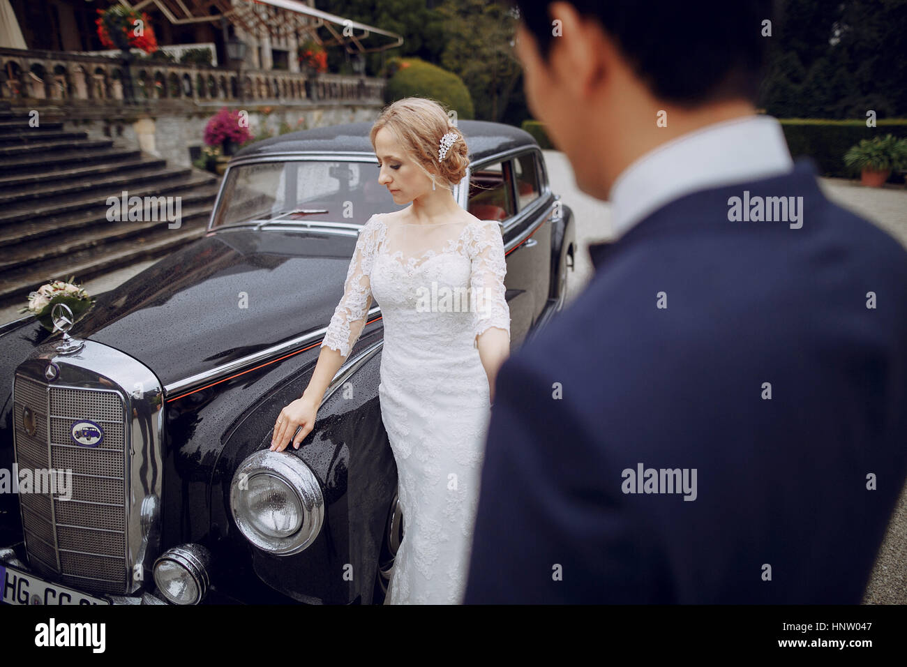 bride and groom standing in the yard near the car Stock Photo - Alamy