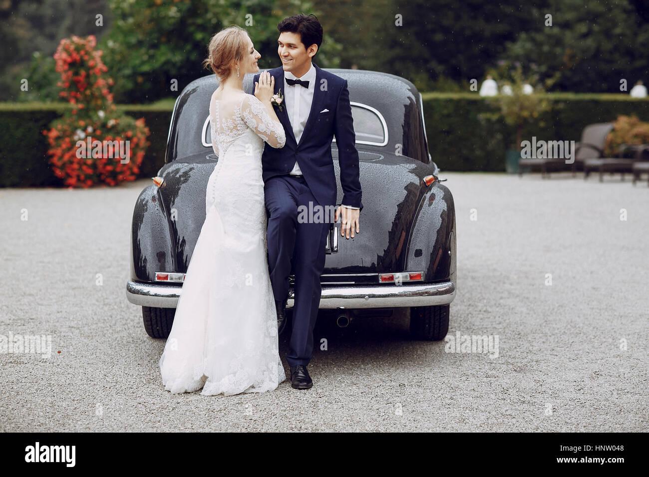 bride and groom standing in the yard near the car Stock Photo - Alamy