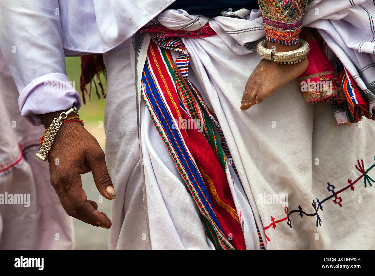 Hands and legs of father and son, from interior village of Kachchh, India, wearing traditional clothes and ornaments Stock Photo