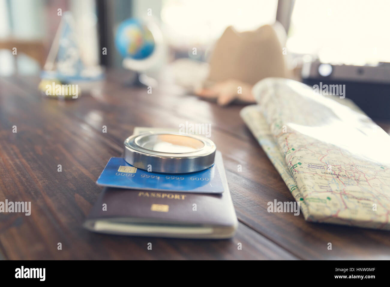 hat, compass, passport, credit card, banknote money, globe, camera, map, car ship and starfish figurine on wooden table for use as traveling concept ( Stock Photo