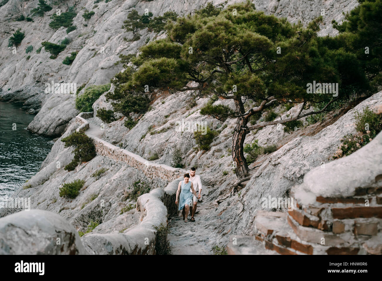 Caucasian couple hiking on cliff near lake Stock Photo