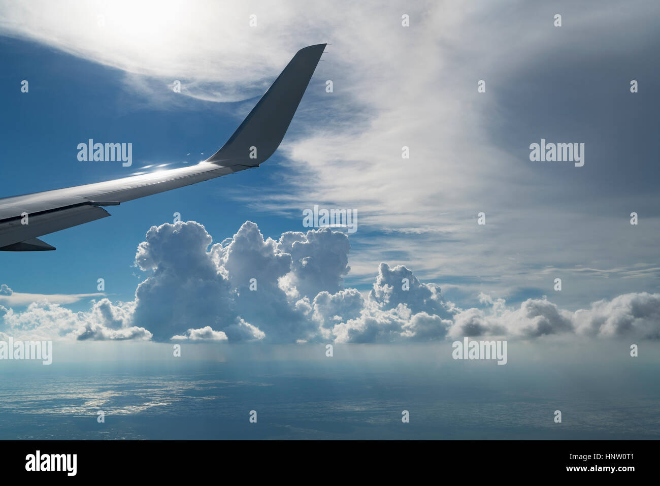 Wing of airplane flying in cloudy sky Stock Photo - Alamy