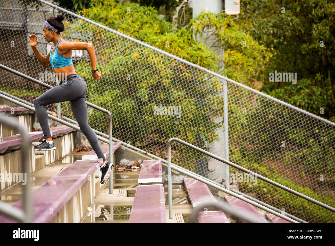 Black woman running on bleachers Stock Photo