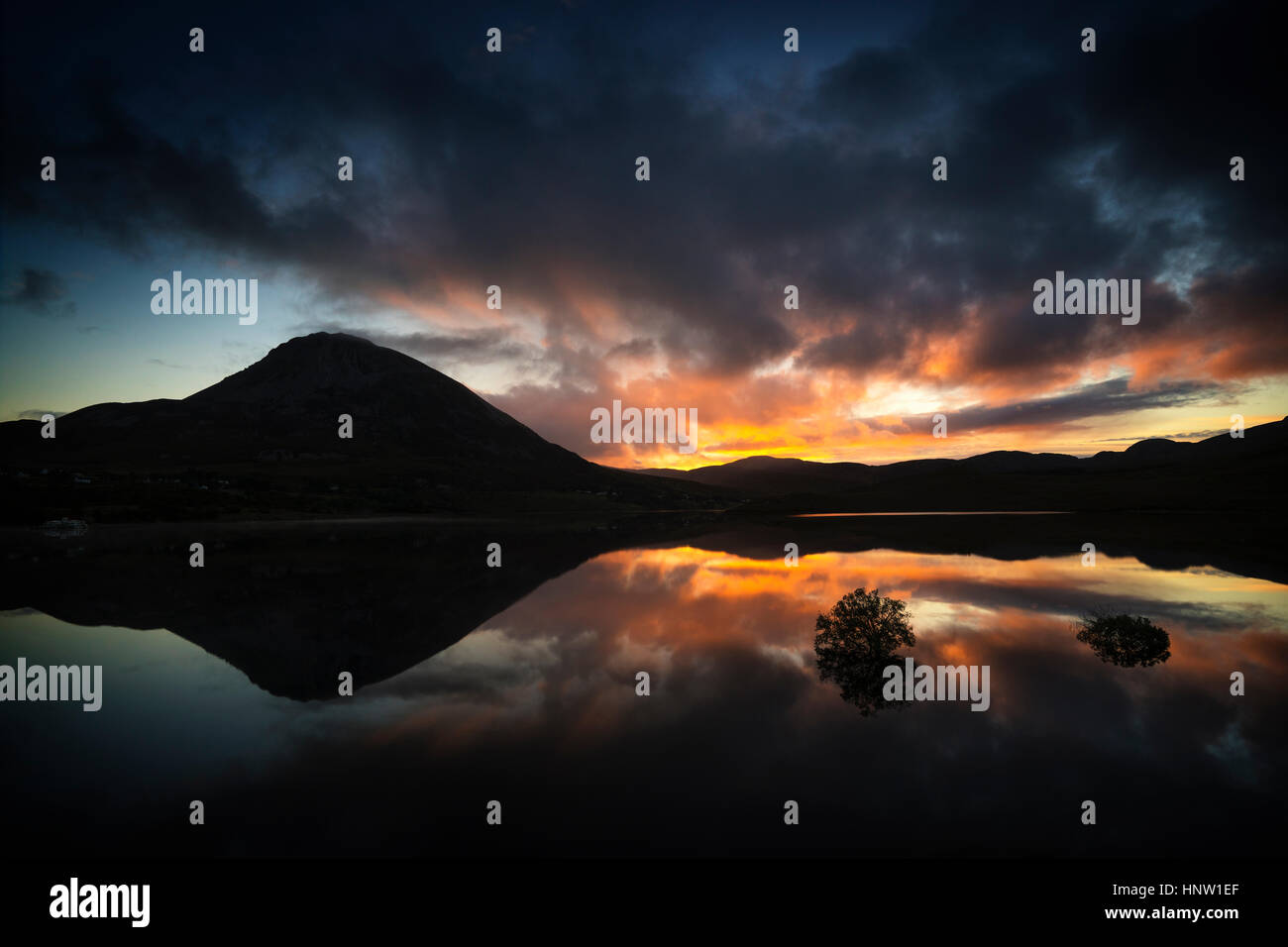 Reflection of sunset and mountain in water Stock Photo