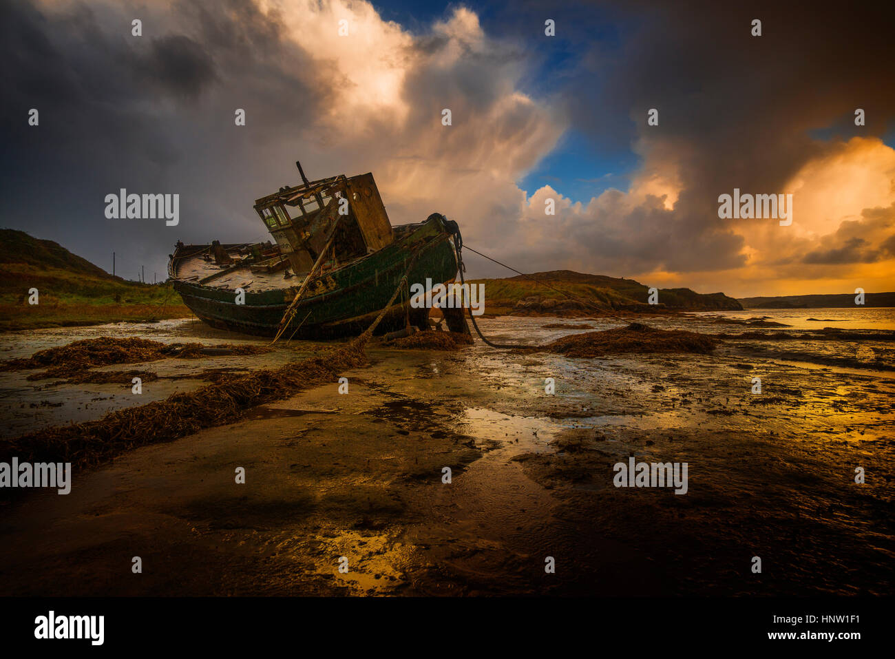 Shipwreck on beach at sunset Stock Photo