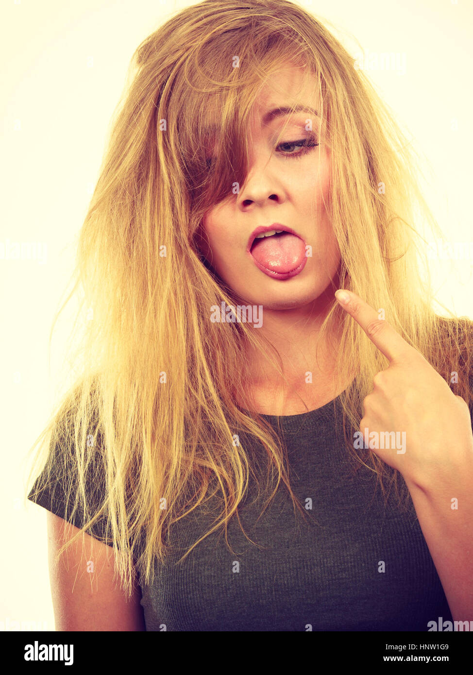 Bad hairstyle, not fresh food concept. Sad blonde woman with messy hair looking tired and dissatisfied, pointing at her tongue. Studio shot on white b Stock Photo - Alamy Bad hairstyle, not fresh food concept. Sad blonde woman with messy hair looking tired and dissatisfied, pointing at her tongue. Studio shot on white b Stock Photo - Alamy