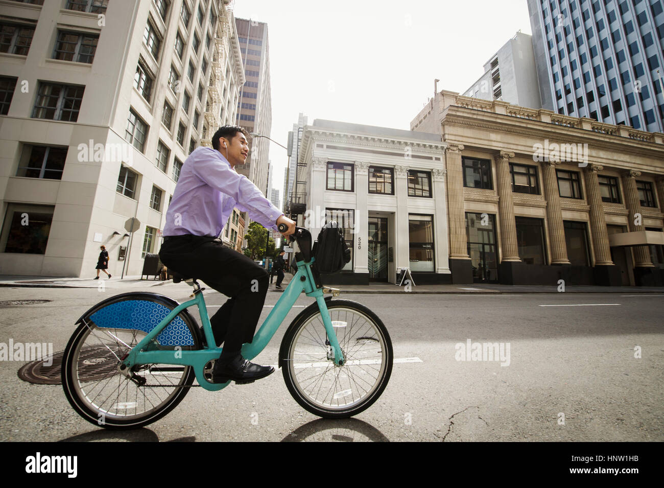 Chinese businessman commuting on bicycle in city Stock Photo