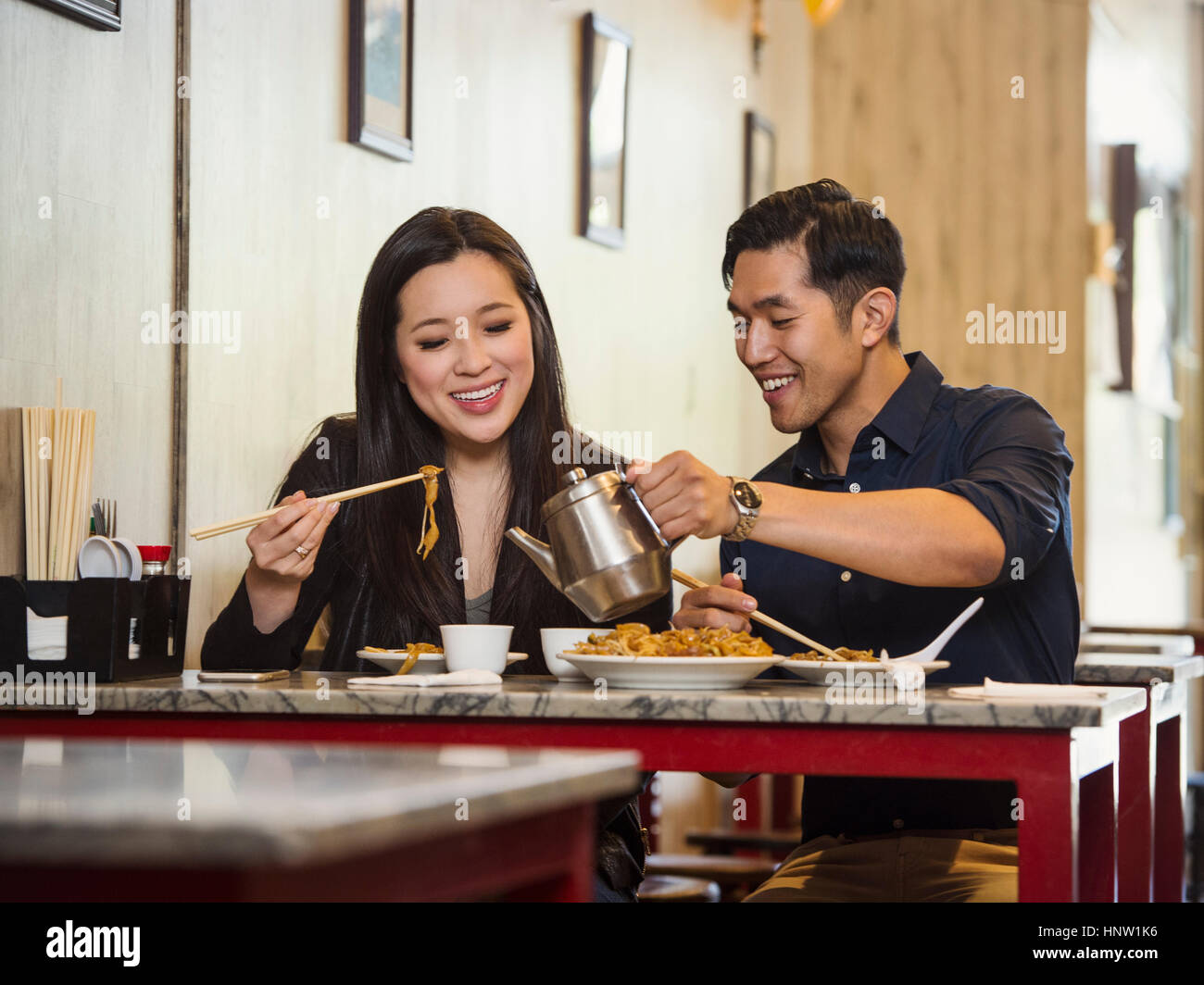 Chinese man pouring tea for woman in restaurant Stock Photo