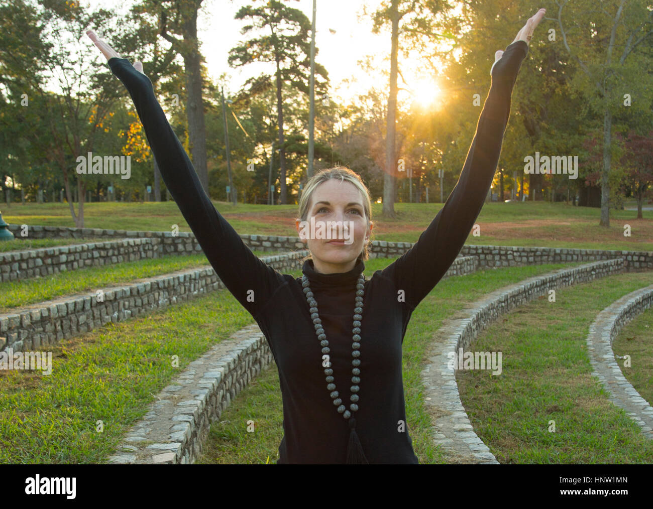 Caucasian woman meditating in park Stock Photo