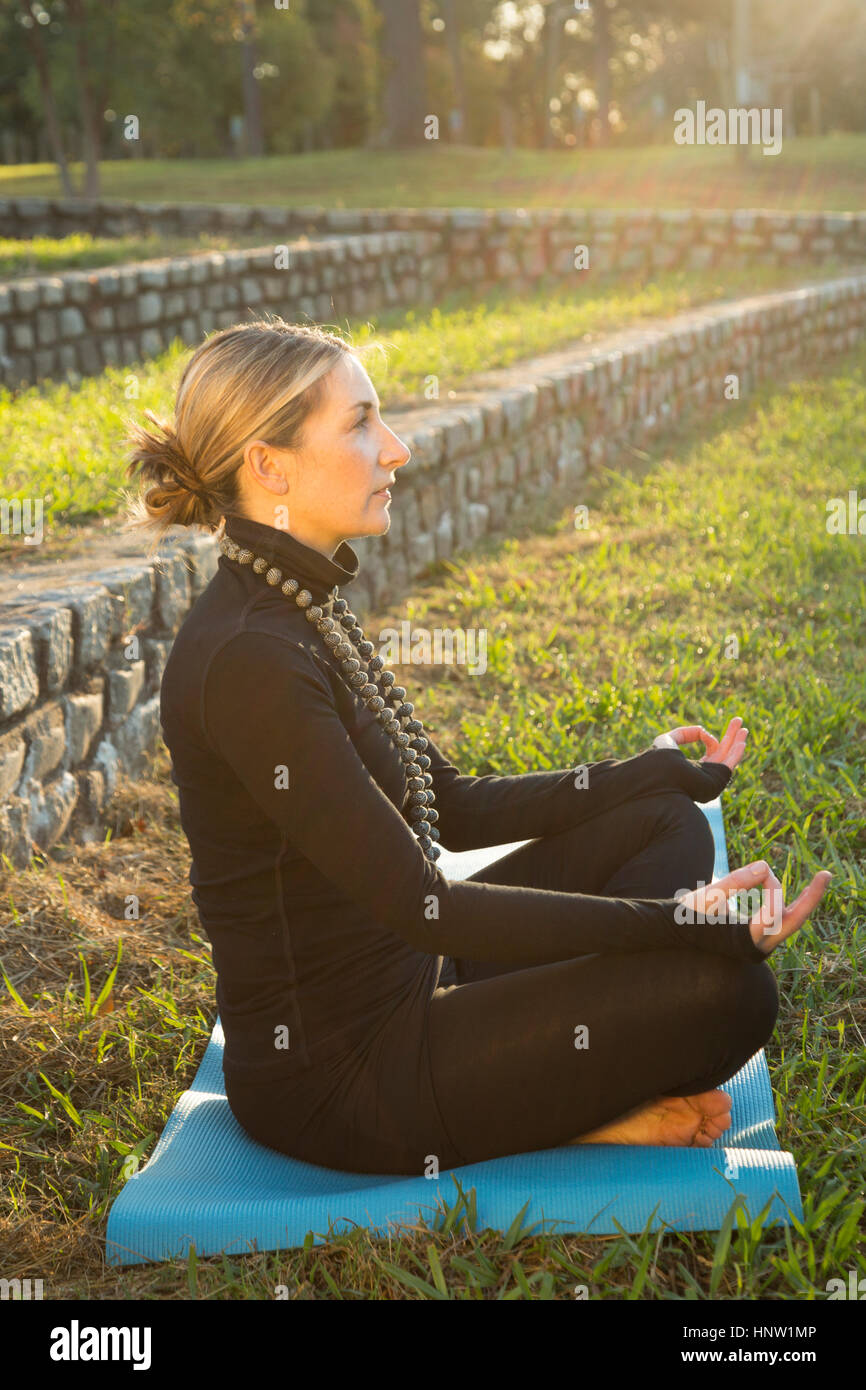 Caucasian woman meditating in park Stock Photo