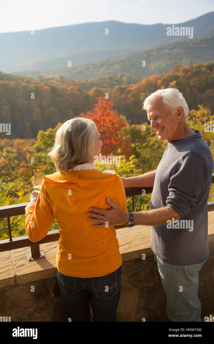 Older Caucasian couple enjoying wine and scenic view Stock Photo