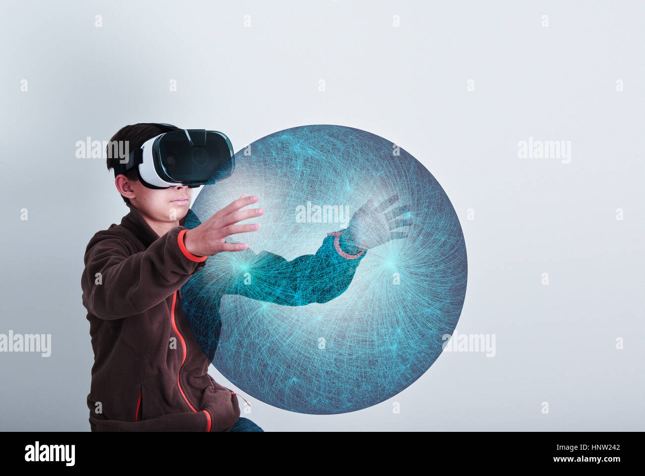 Mixed Race boy wearing VR goggles holding sphere Stock Photo