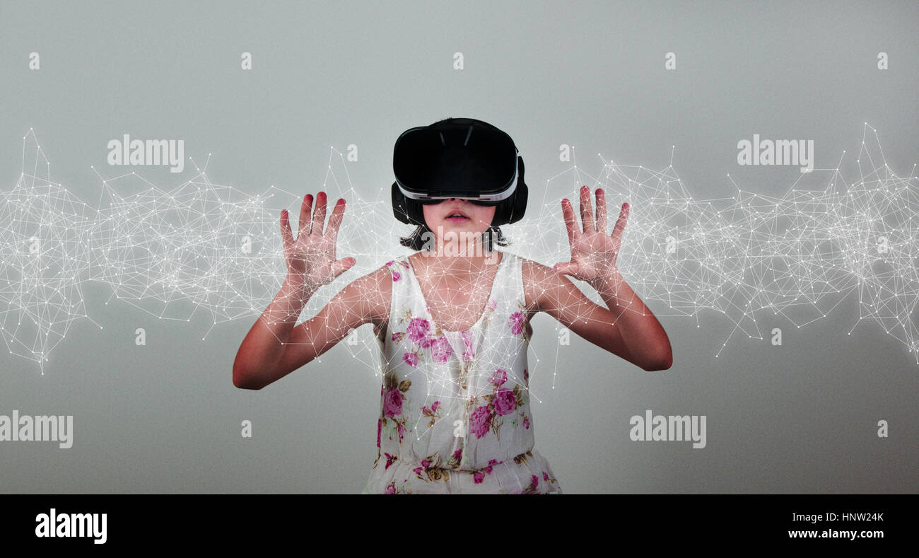 Mixed Race girl wearing virtual reality goggles Stock Photo