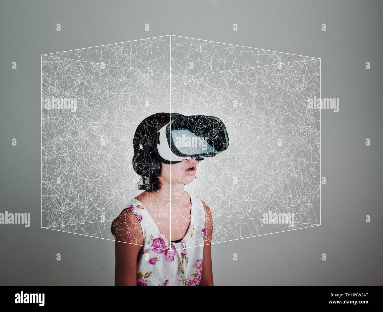 Mixed Race girl wearing virtual reality goggles in floating box Stock Photo