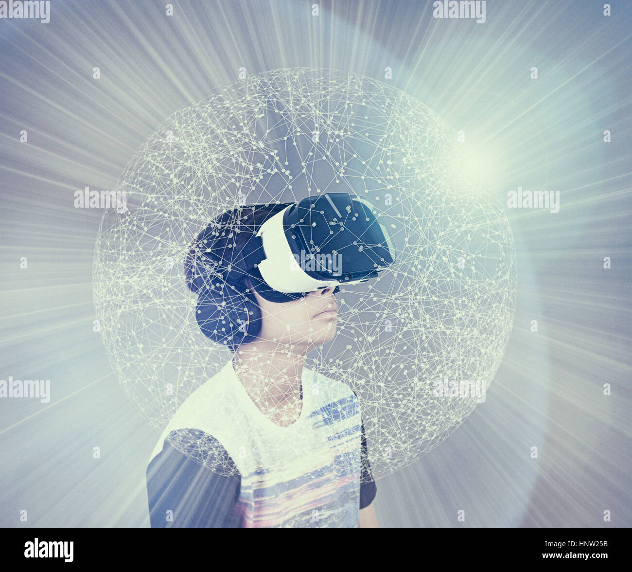 Mixed Race boy wearing virtual reality goggles in glowing sphere Stock Photo