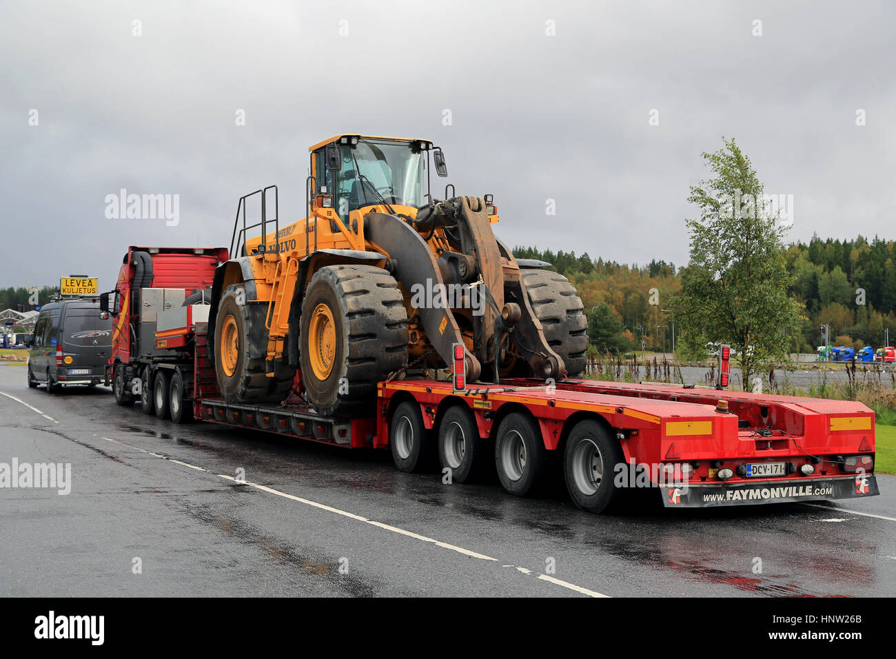 FORSSA, FINLAND - SEPTEMBER 4, 2016: Volvo FH12 semi trailer is ready to transport a large Volvo wheel loader on Faymontville gooseneck trailer as wid Stock Photo