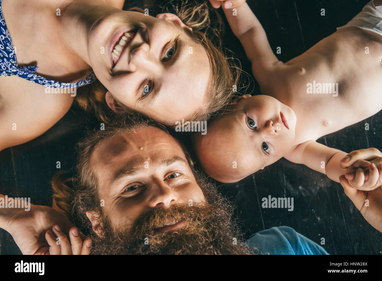 Caucasian parents laying on floor with daughter Stock Photo