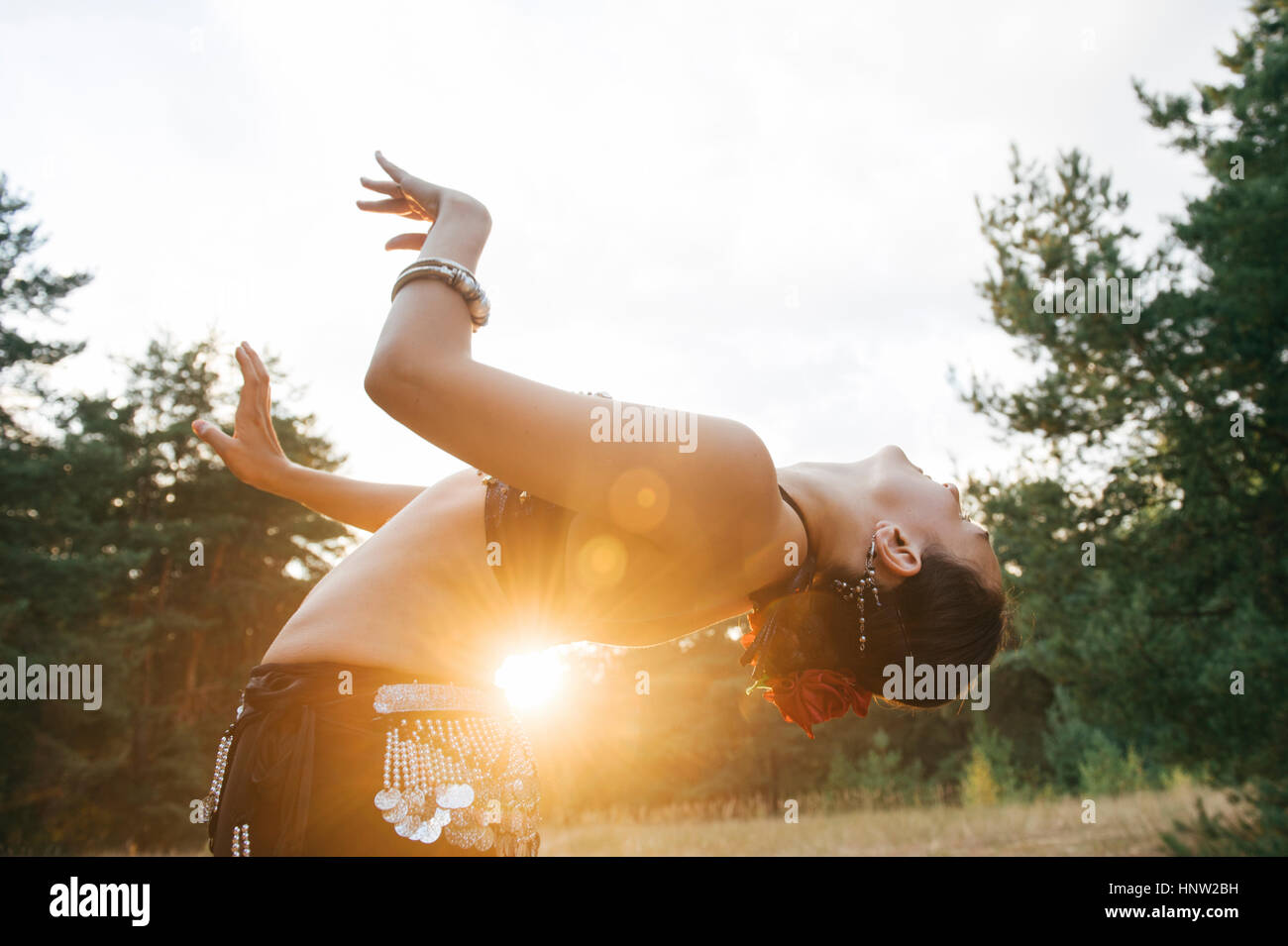 Caucasian belly dancer in field leaning backward Stock Photo