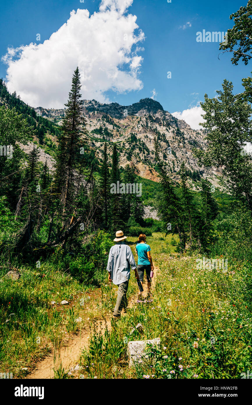 Caucasian couple hiking on path in mountains Stock Photo