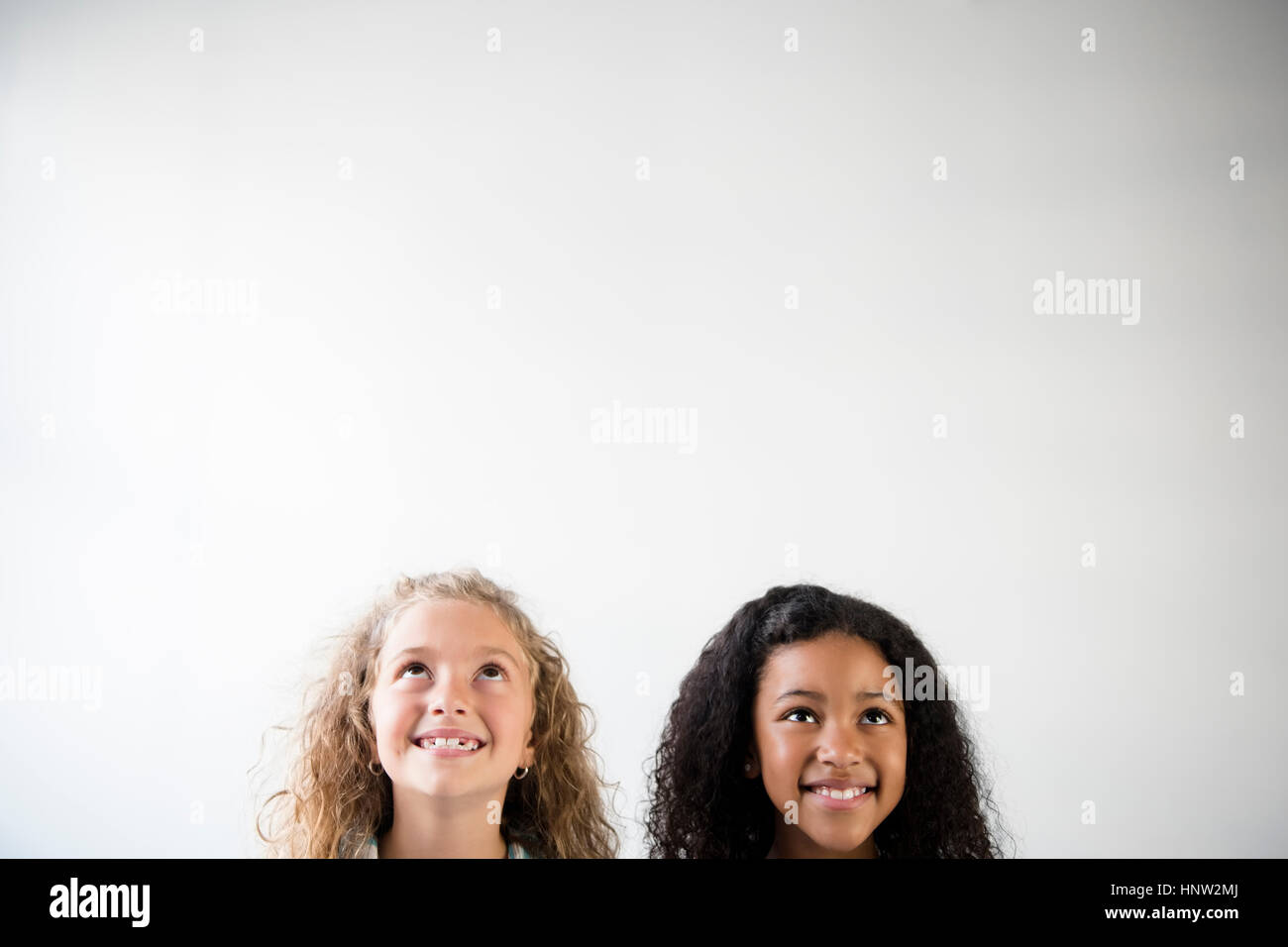 Faces of smiling girls looking up Stock Photo