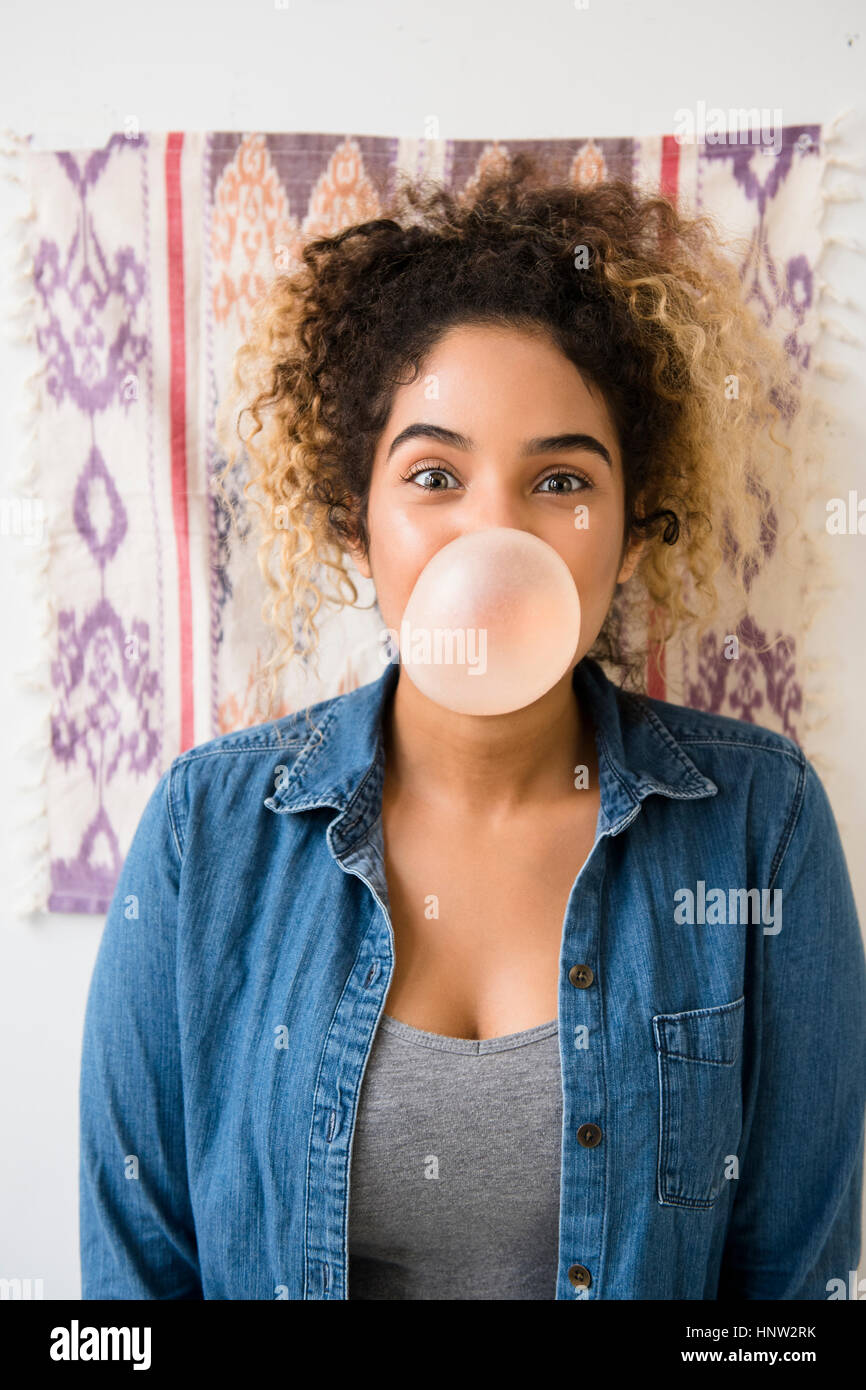 Mixed Race woman blowing bubble with gum Stock Photo