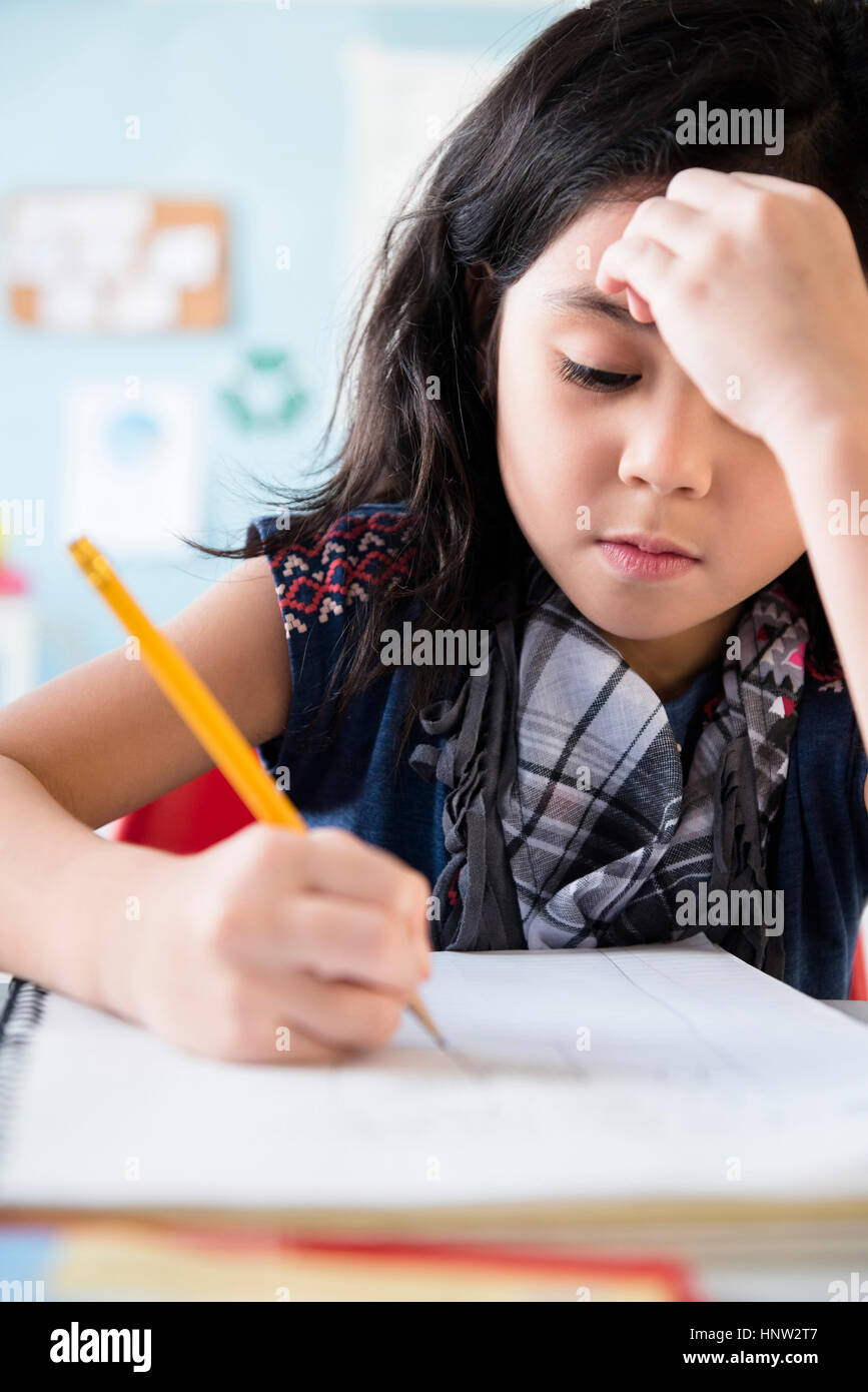 Caucasian girl writing in notebook at school Stock Photo