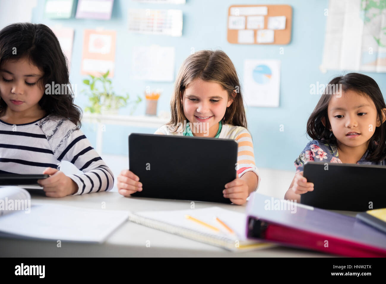 Girls using digital tablets in classroom Stock Photo Alamy