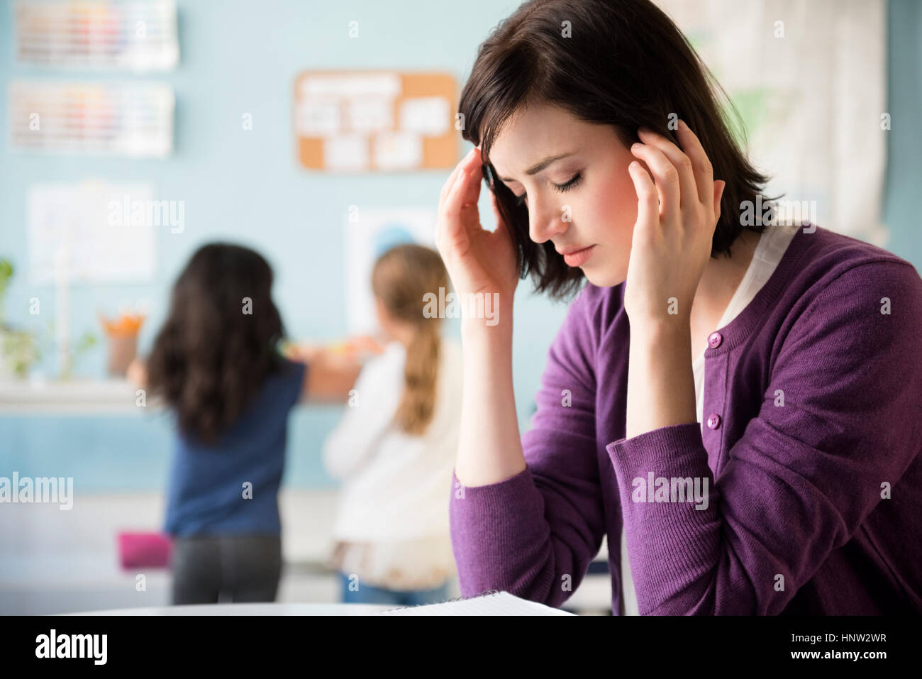 Caucasian teacher with headache in classroom Stock Photo