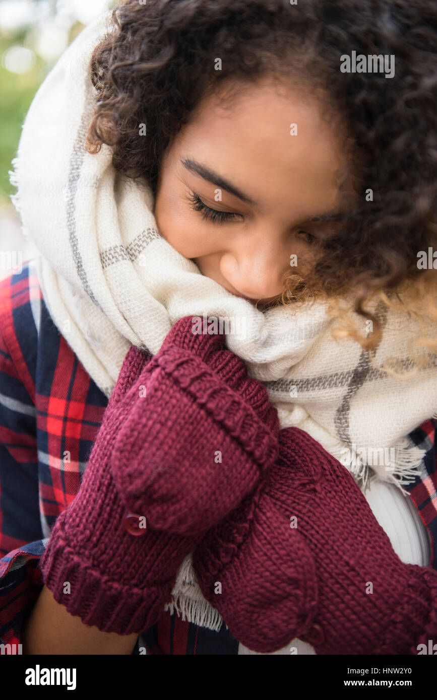 Mixed Race woman covering face with scarf Stock Photo